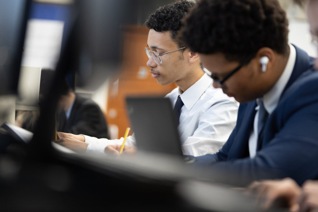 Two male students are pictured working individually in a quiet space.
