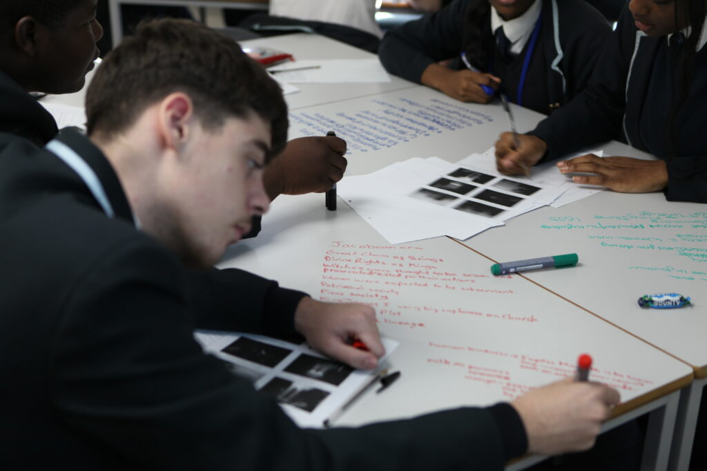 A small group of Year 11 students are seen concentrating on their work, whilst sat at their desks during a Macbeth Workshop.