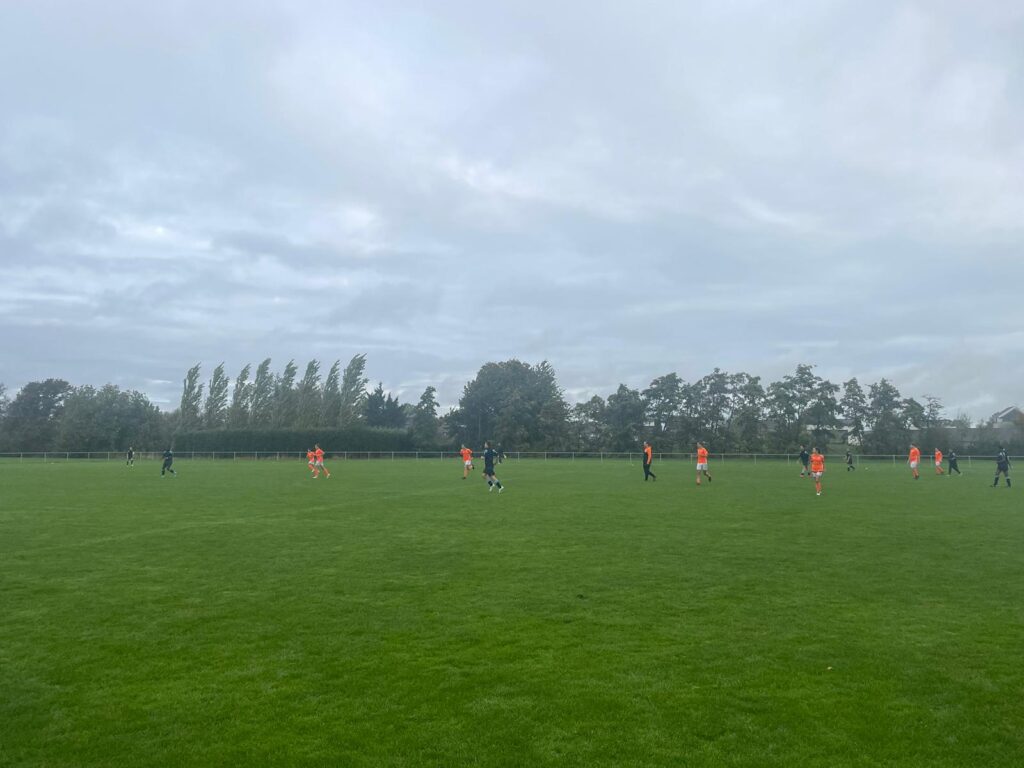 Students seen playing Football on a field on the academy grounds on a cloudy day.
