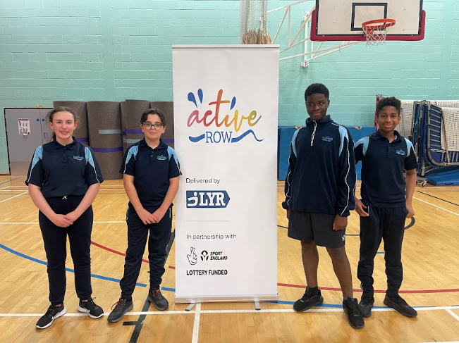 Participants in a Rowing Competition at Sir Joseph Williamson's Mathematical School pose for the camera in a group photo in the Sports Hall.