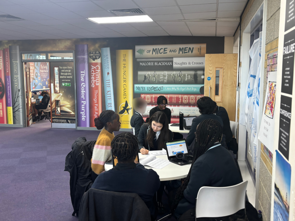 Students sat around tables completing work and supporting one another