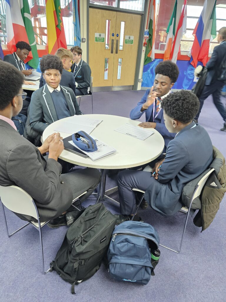 Students sat around tables completing work and supporting one another