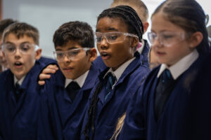 Pupils wearing safety goggles in a classroom setting looking amazed